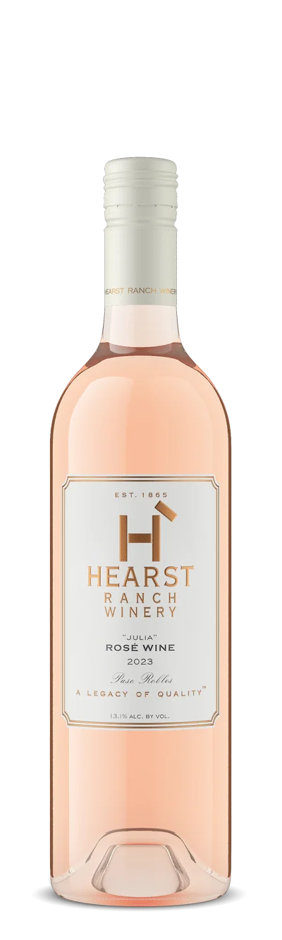 A bottle of Hearst Ranch Winery Rosé Wine 2023 with a white and gold label and a white cap, standing upright against a light background. TheCentralCoast.com