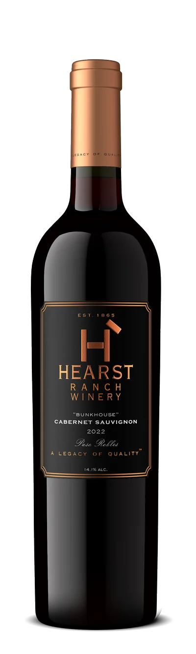 A bottle of Hearst Ranch Winery 2022 Cabernet Sauvignon with a copper-colored foil top and a black and gold label. TheCentralCoast.com