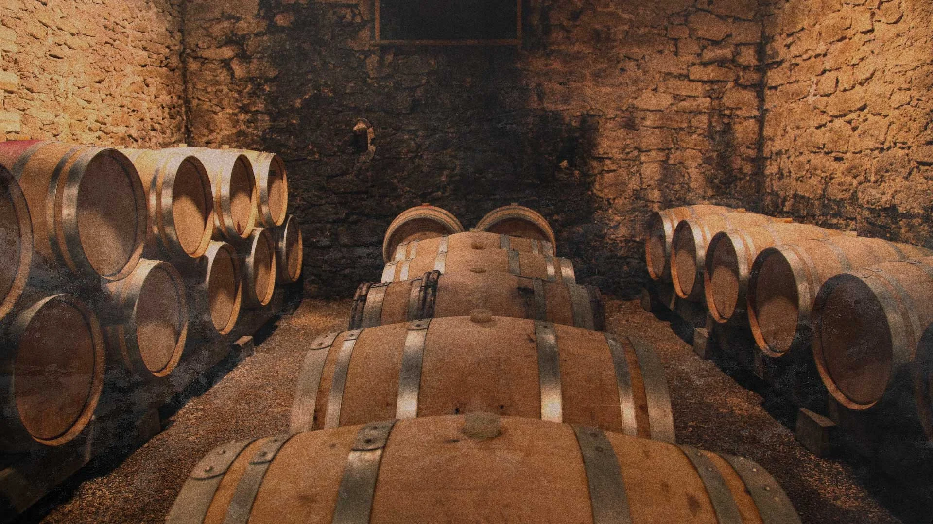A dimly lit stone cellar with rows of wooden barrels lined up along the walls and in the center, used for aging wine or spirits. TheCentralCoast.com